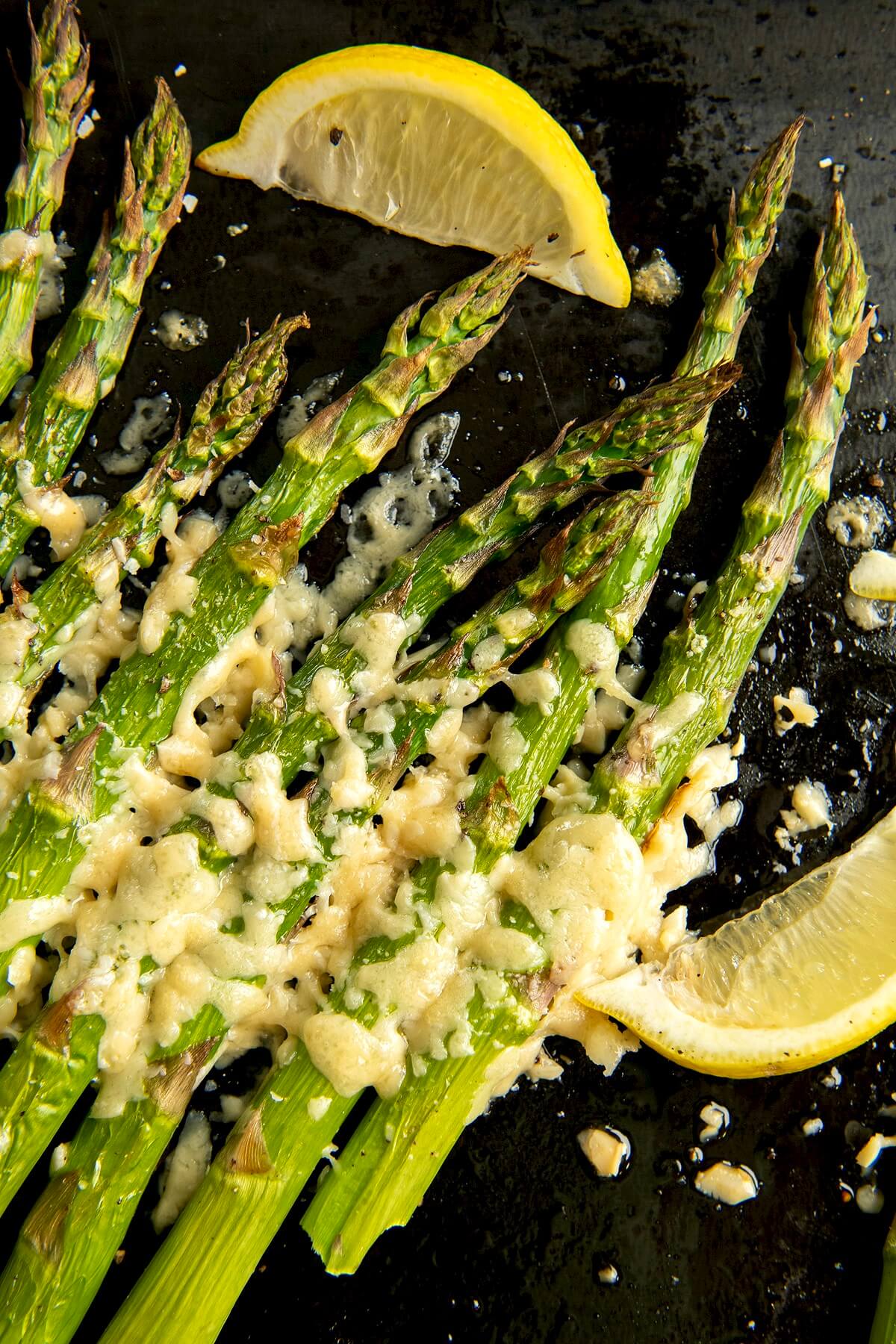 Asiago cheese provides a delightful alternative to Parmesan, adding a unique twist to simply roasted asparagus. The flavor of this side dishes belies its ease. Lemon slices make a pretty garnish.