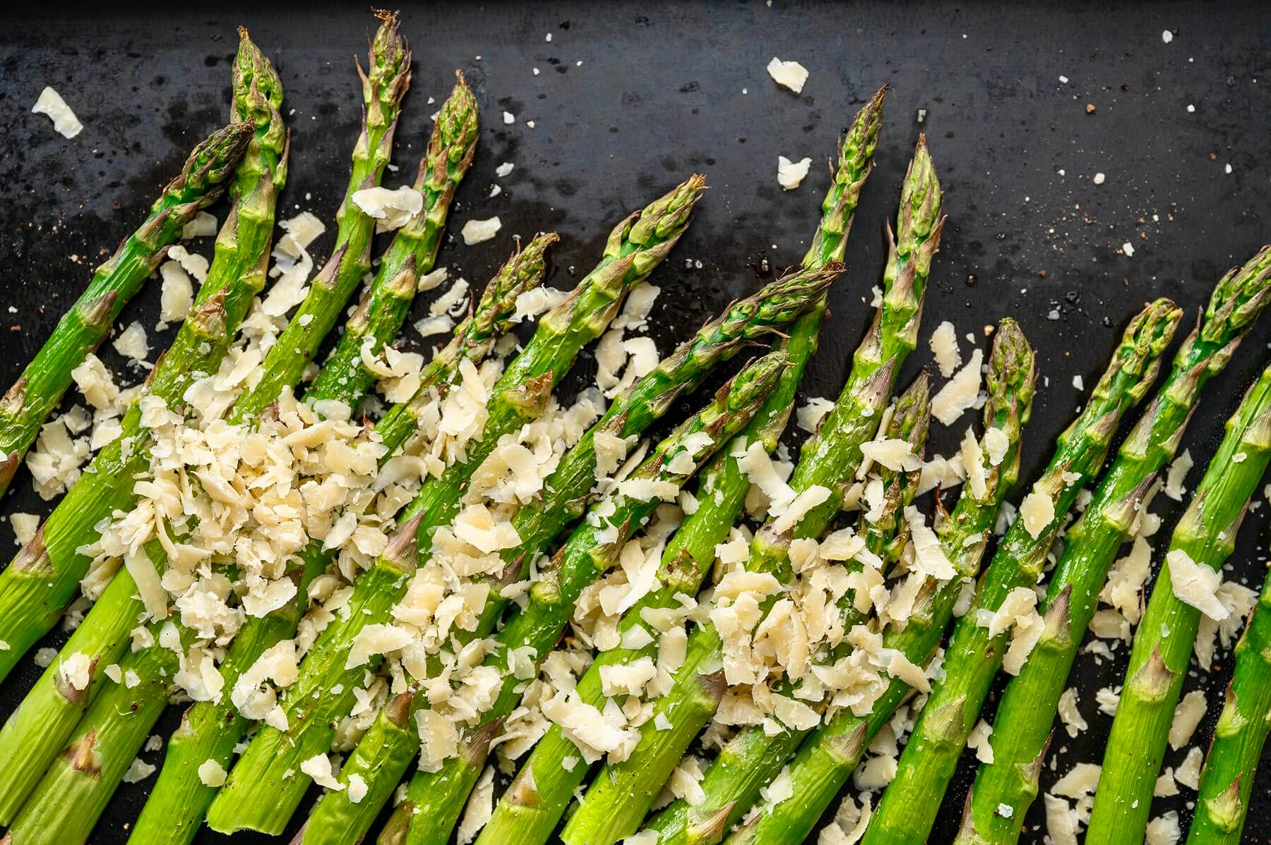 Asiago cheese provides a delightful alternative to Parmesan, adding a unique twist to simply roasted asparagus. The flavor of this side dishes belies its ease. Lemon slices make a pretty garnish.