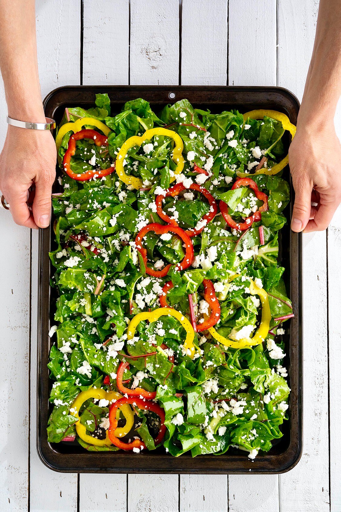 Crave-worthy greens are easy thanks to this unique method of preparation that delivers crisps edges and golden brown bits of feta...all while adding a few other colorful veggies to the mix