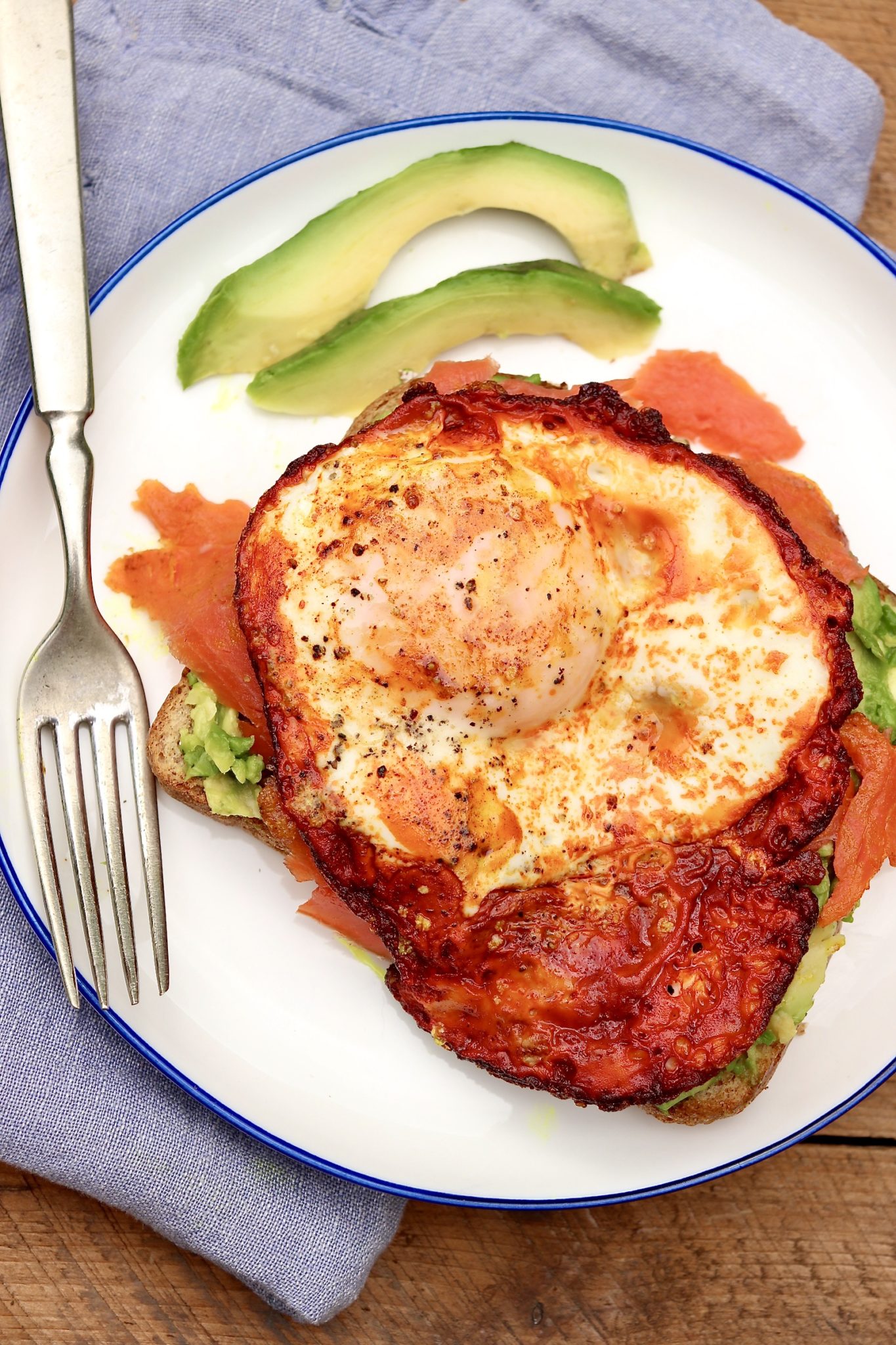 A crispy, turmeric-infused egg and a layer of Omega-3 rich salmon take the beloved avocado toast to soaring new heights!