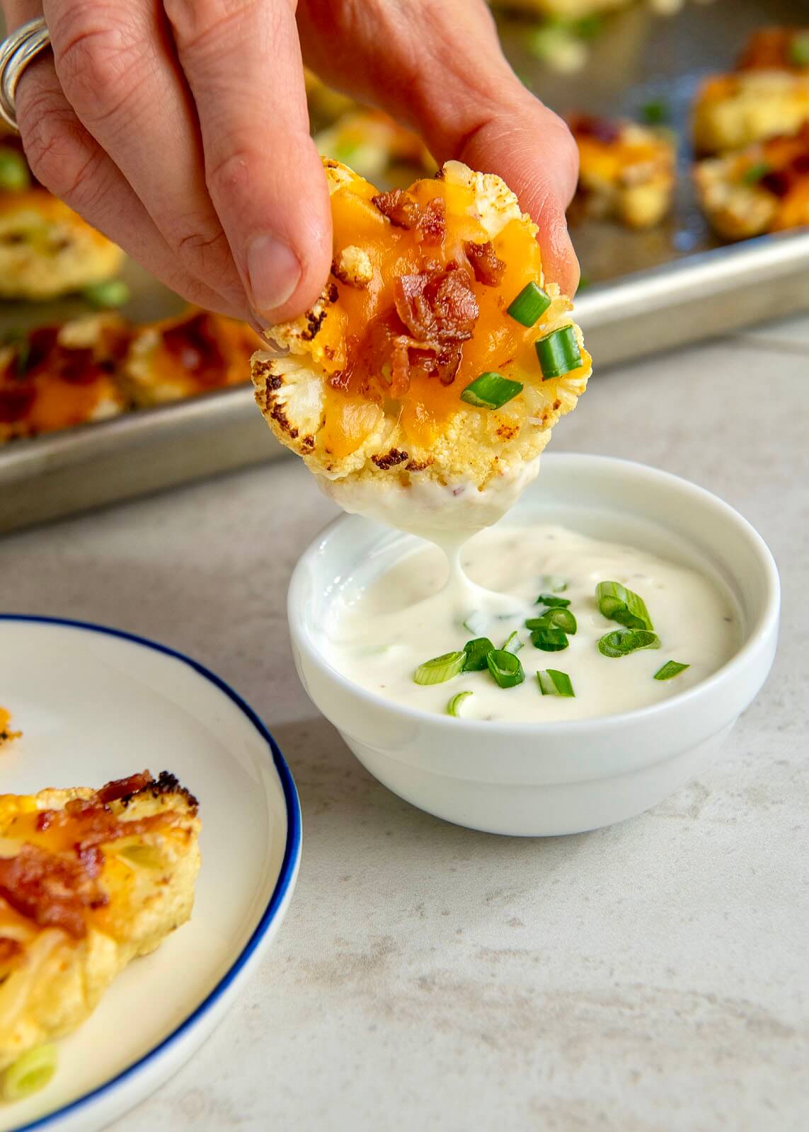 Roasted cauliflower is topped with bacon and cheese in this satisfying twist on baked potato skins that can be served as an appetizer or family-friendly side dish. A "steak" option makes for a heartier side dish, and a few extra ingredients will turn the recipe into a protein-rich meal.