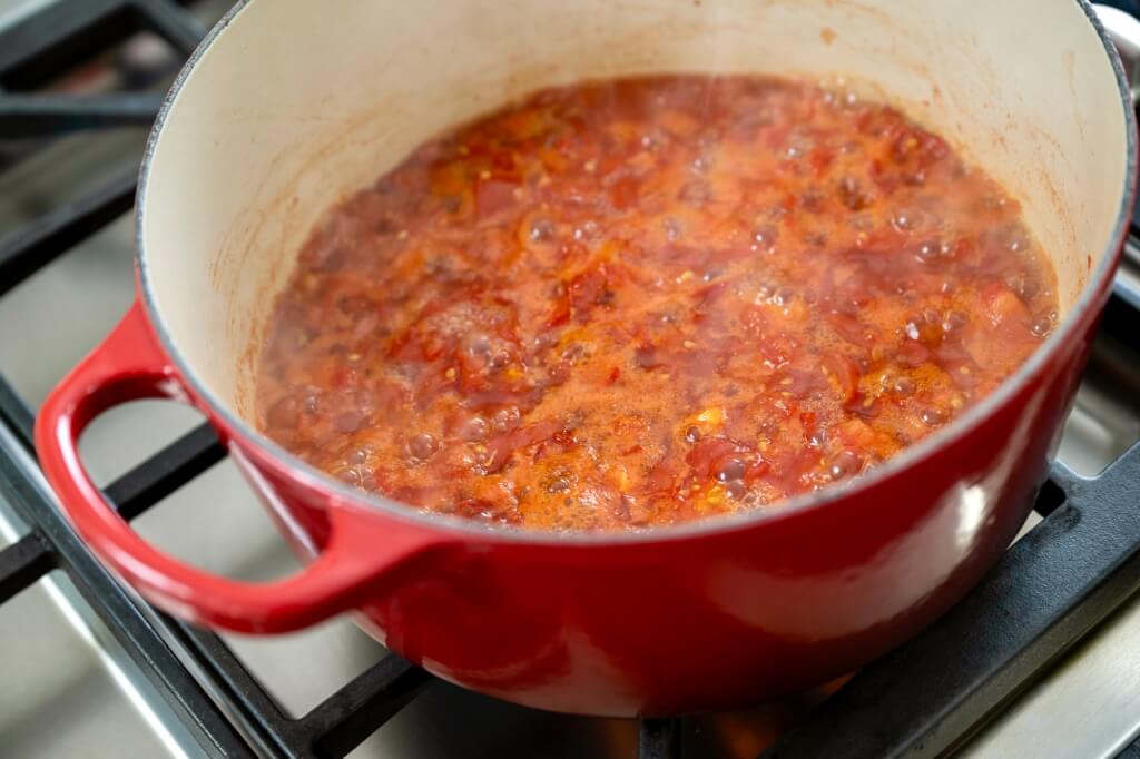 Easy-to-make tomato jam is savory and tangy with a hint of spicy sweetness. An ideal way to use a bumper crop of tomatoes, the rustic jam is a delightful alternative to ketchup on a burger or chutney on grilled chicken, fish, or pork.